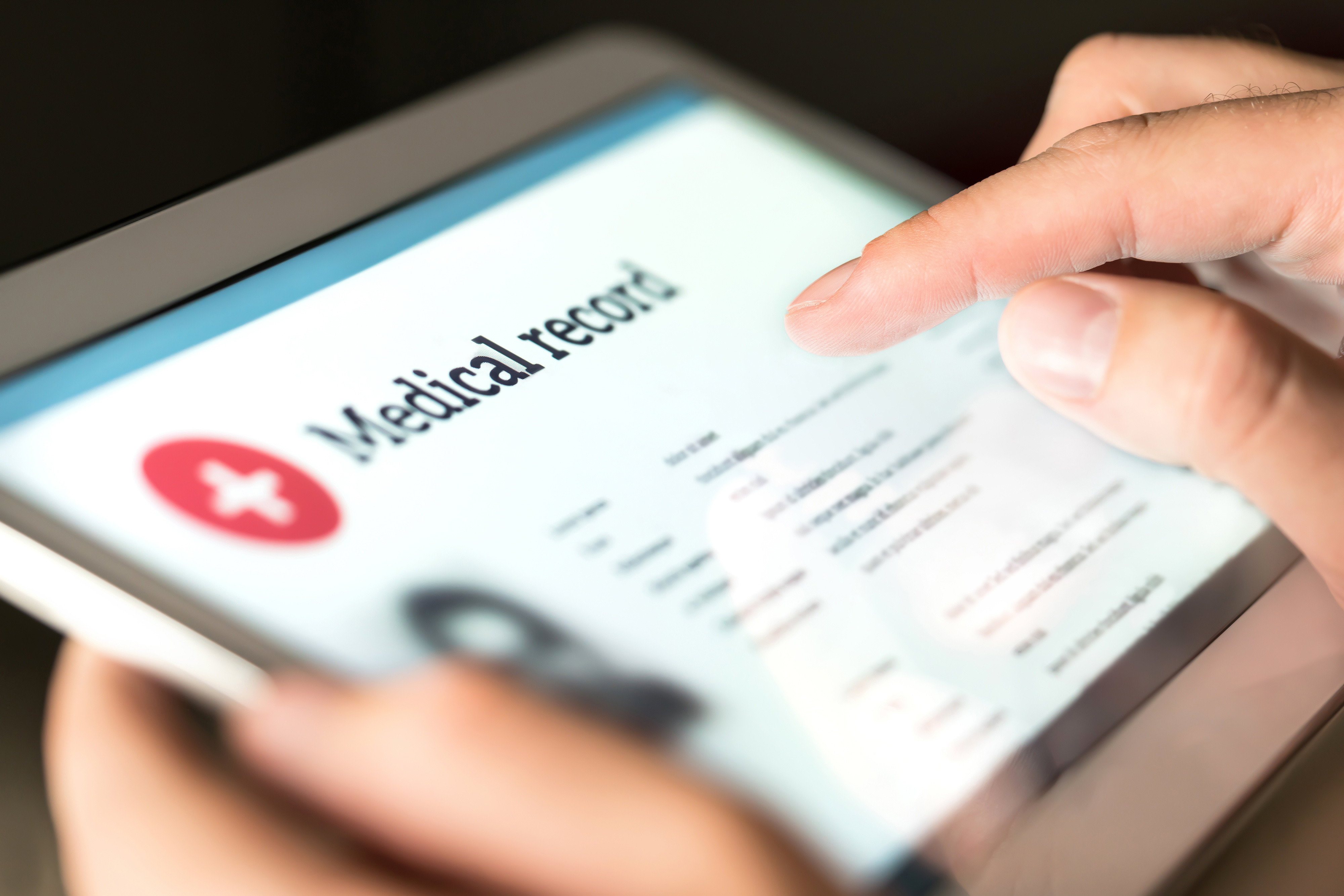 Image of clinician reviewing medical record to create a summary